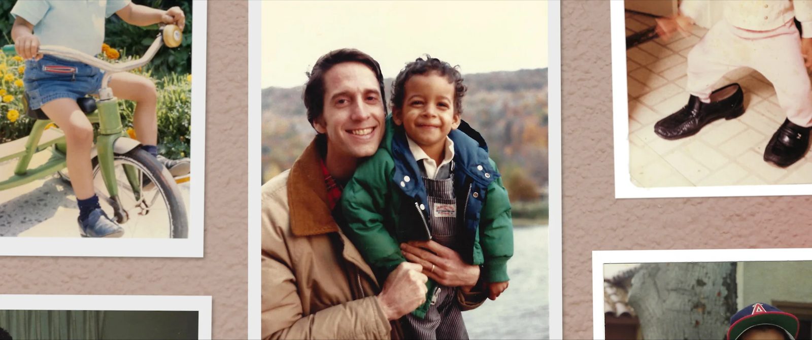 A father holding his young son, surrounded by family photographs. A scene from Let Me Have My Son.